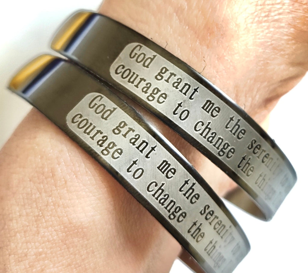 Engraved stainless steel prayer cuff bracelet close-up on wrist, polished bangle