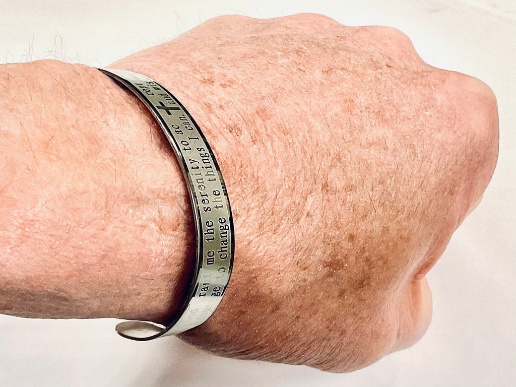 Stainless steel prayer cuff bracelet engraved with words on wearer’s wrist