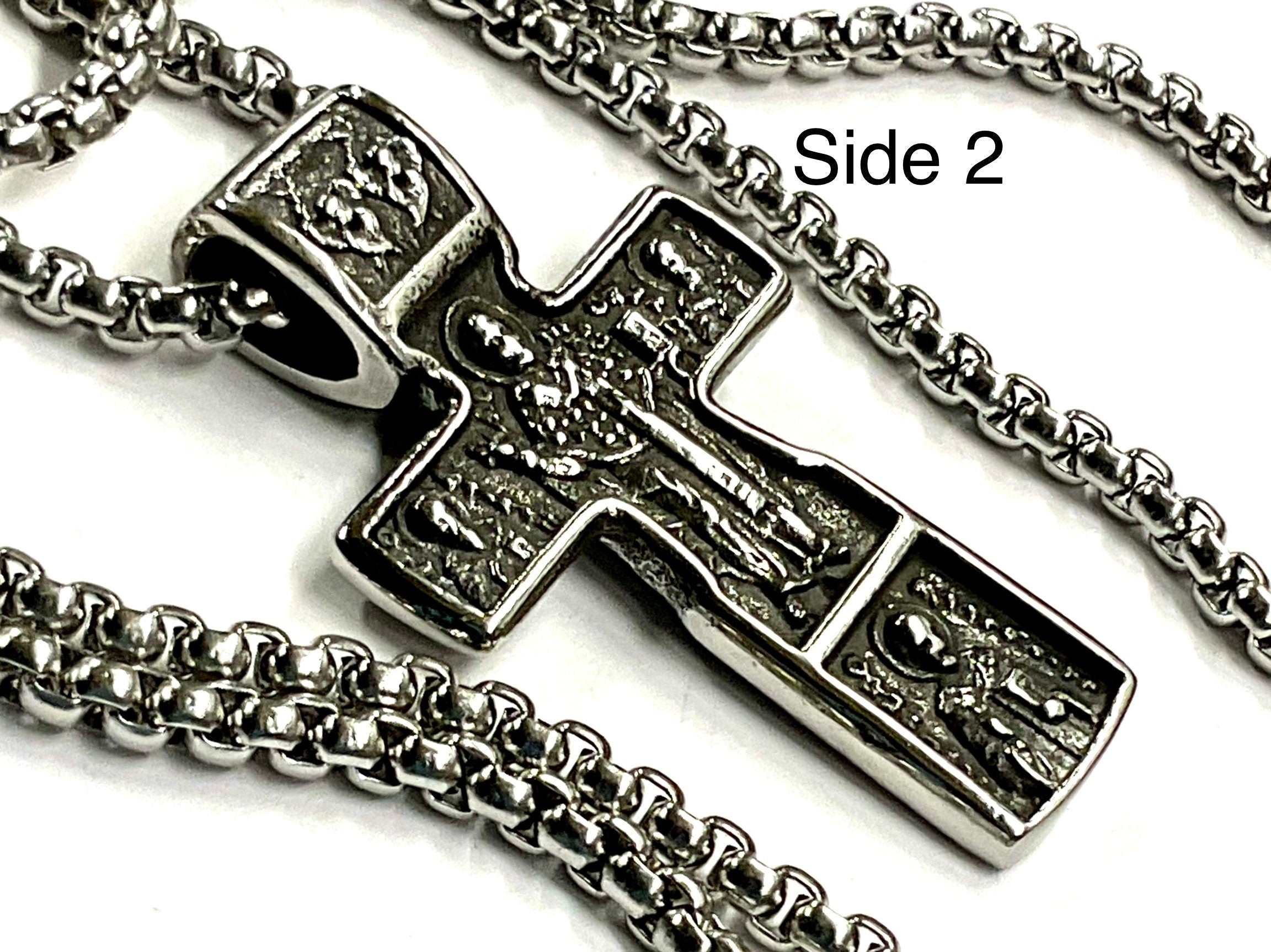 Silver crucifix cross pendant necklace close-up with embossed figure and chain