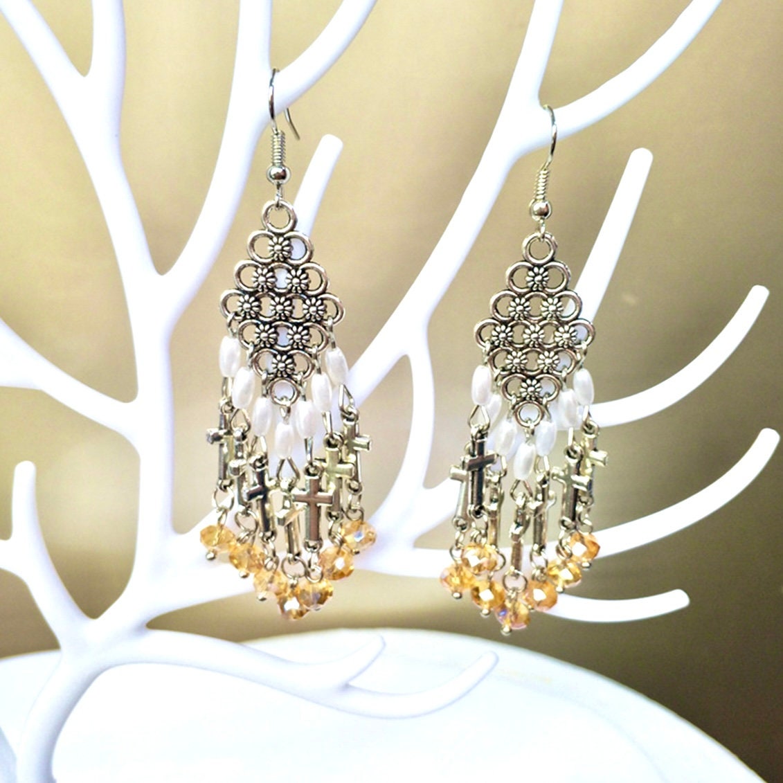 Silver-tone ornate cross dangle earrings with pearl beads and dark yellow glass beads