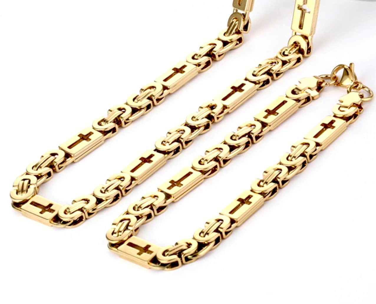 Gold-tone cross charm chain necklaces and bracelet chains, laid flat