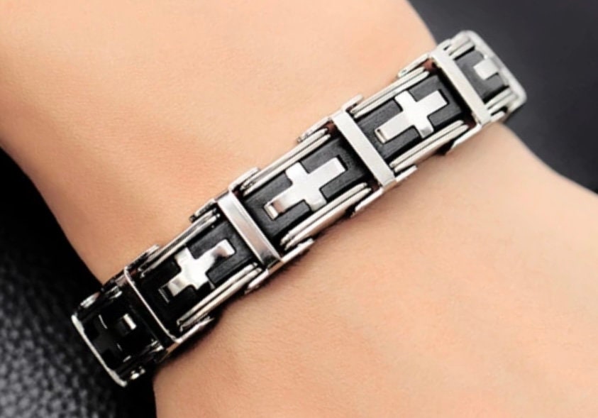 Close-up of stainless steel bracelet links with black insets and cross pattern