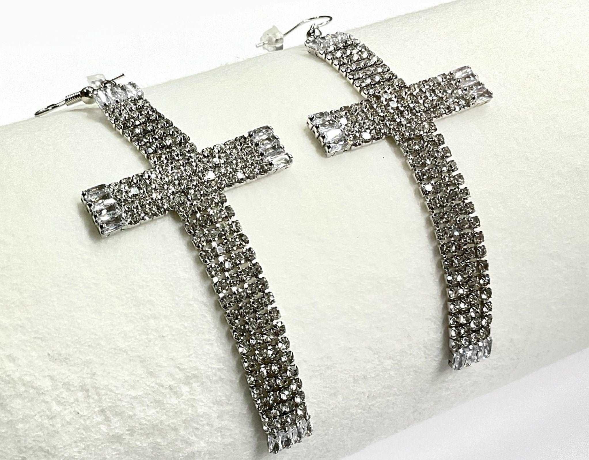 Rhinestone cross dangle earrings, close-up of long cross with square end studs