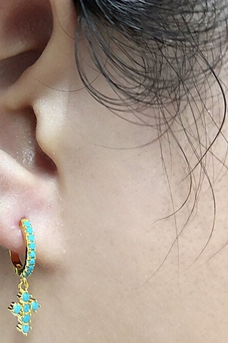 Turquoise beaded cross hoop earrings, gold-tone, close-up on ear