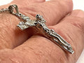 Close-up of silver crucifix pendant with gold-toned Jesus figure on chain