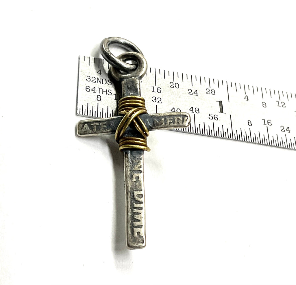 Cross pendant with gold wire wrap and silver-tone bail shown with measurement ruler