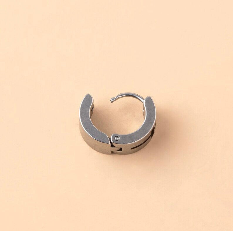 Stainless steel hoop huggie earring with clam closure, dark cross detail