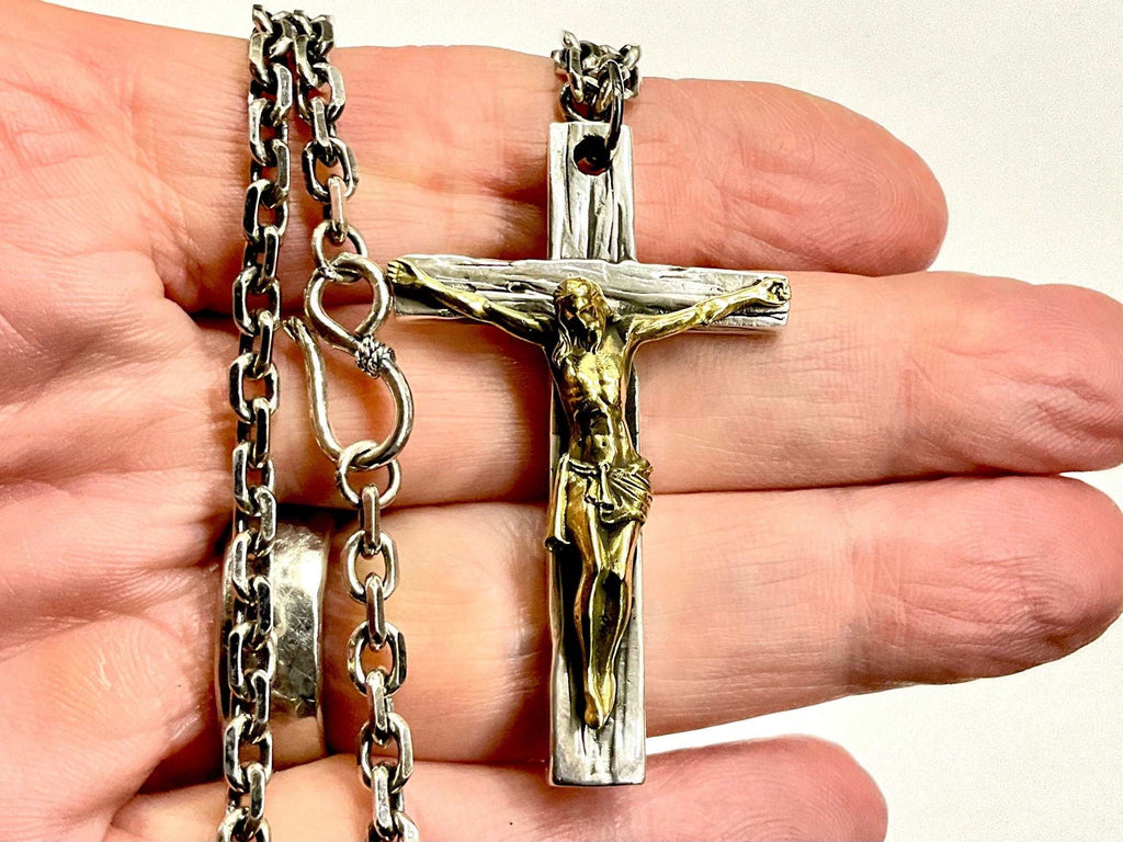 Silver cross necklace with gold-toned crucifix pendant and linked chain