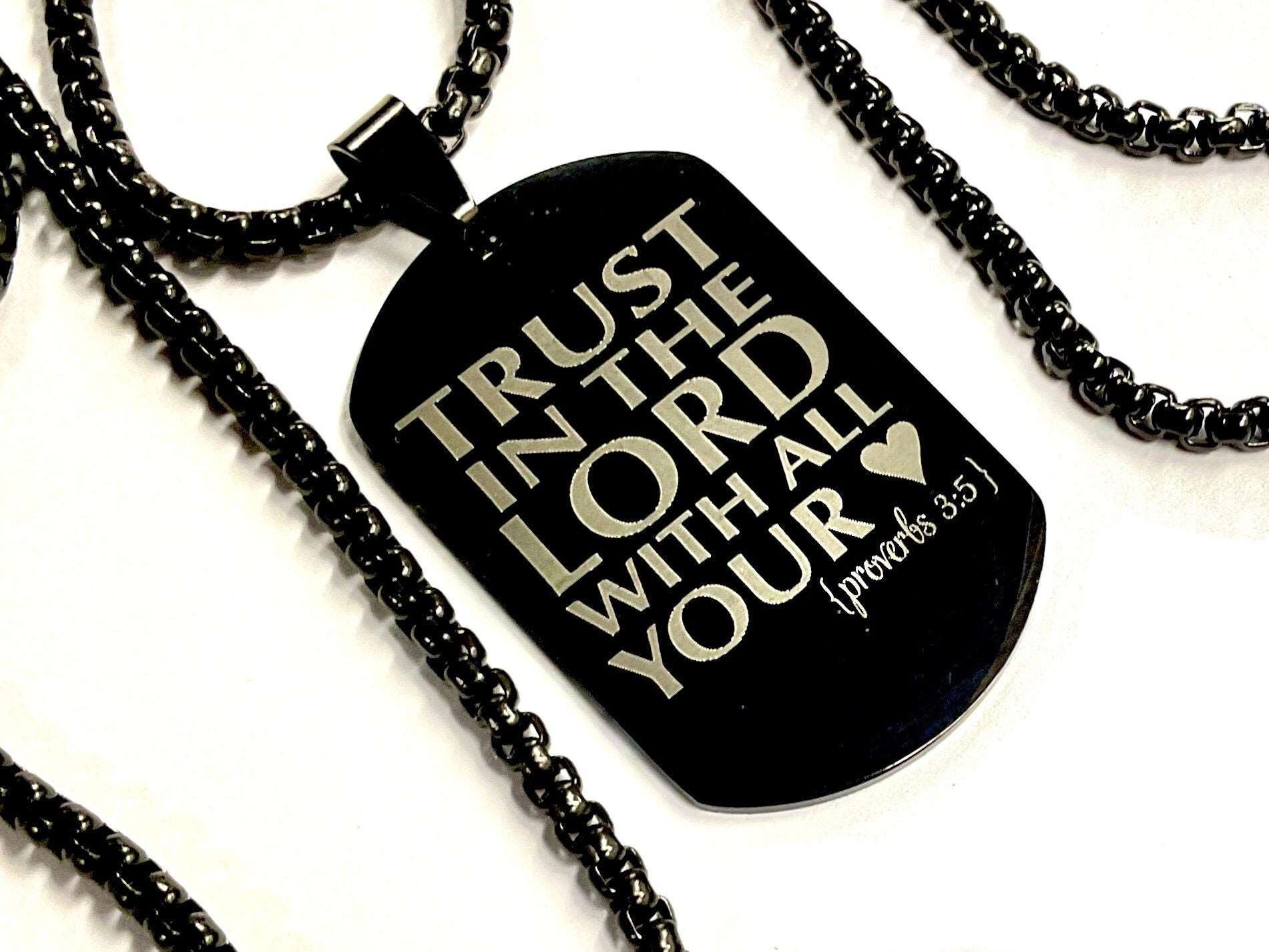 Black dog tag necklace pendant on black chain, engraved scripture text.