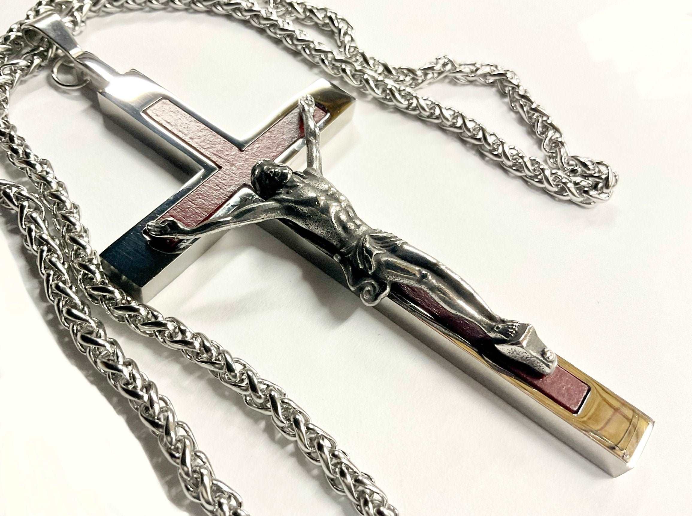Crucifix cross pendant necklace with silver chain and red inlay, flat lay
