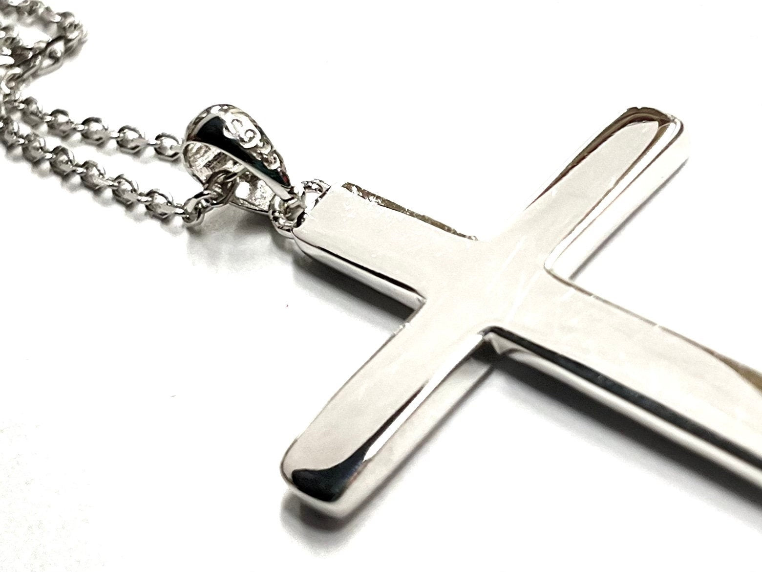 Sterling silver cross pendant necklace with bail and chain on white background