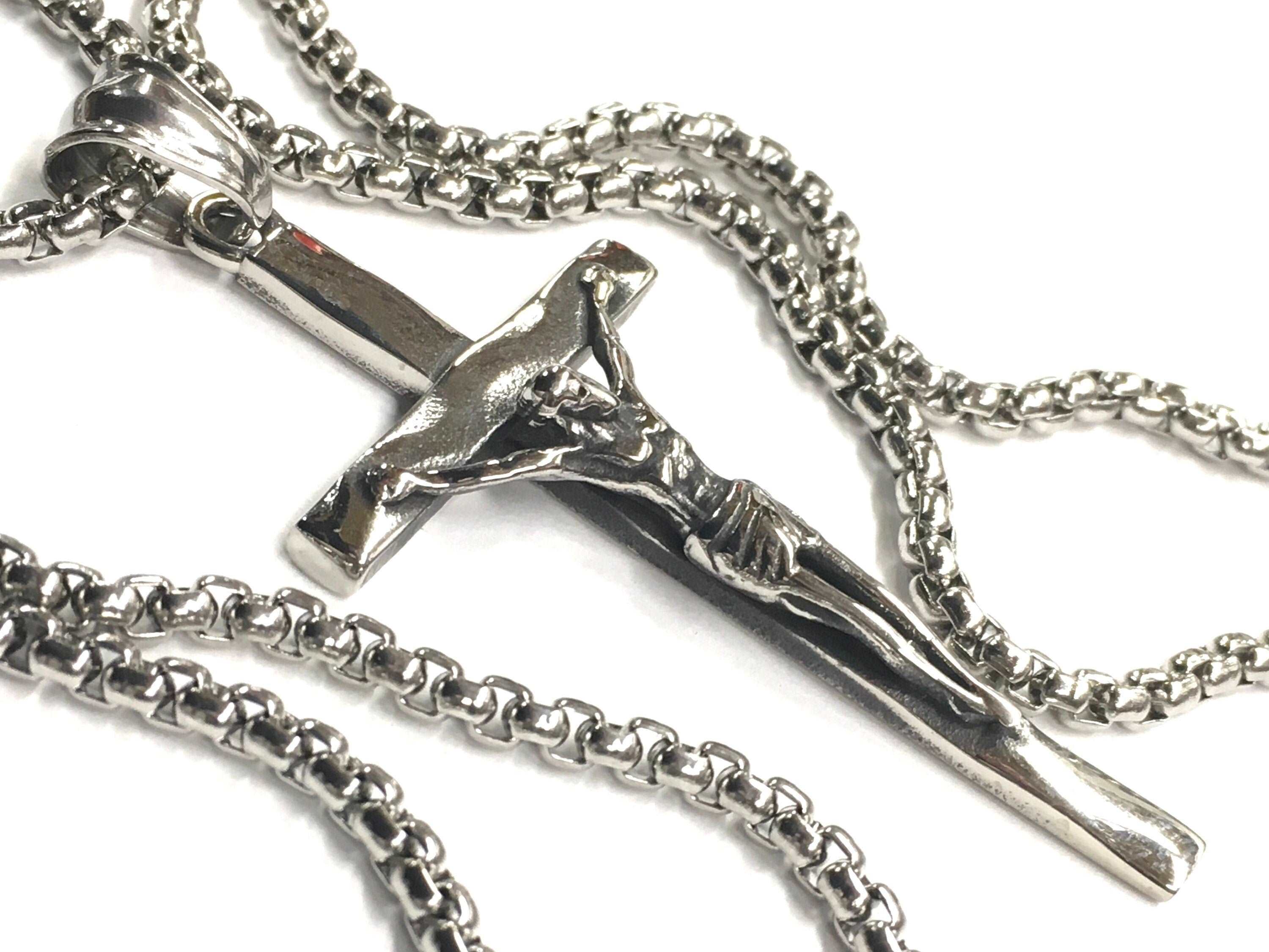 Stainless steel crucifix pendant with link chain, polished, detailed Jesus figure.