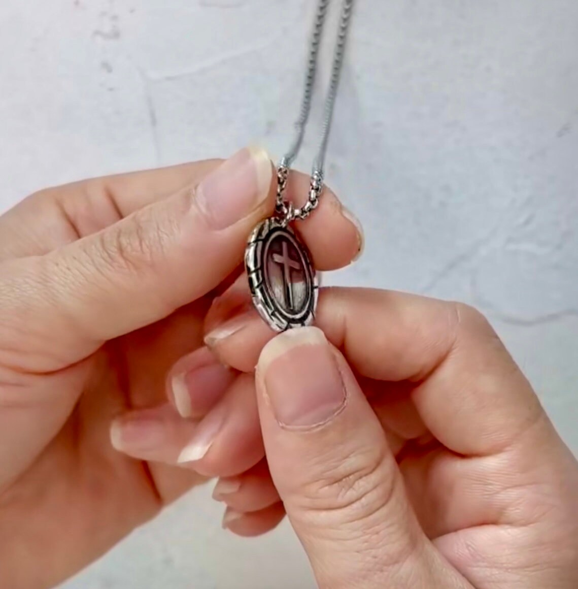 Oval cross pendant necklace with oval frame and vertical cross, silver-tone