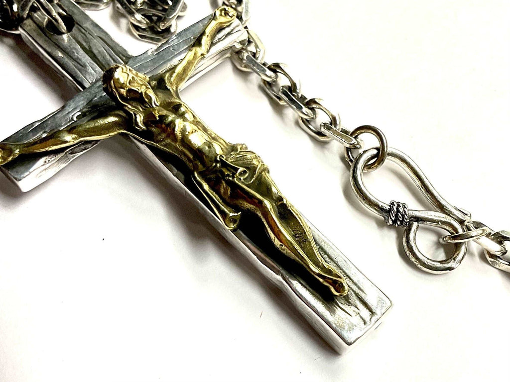 Crucifix cross necklace with silver and gold-toned figure and attached chain