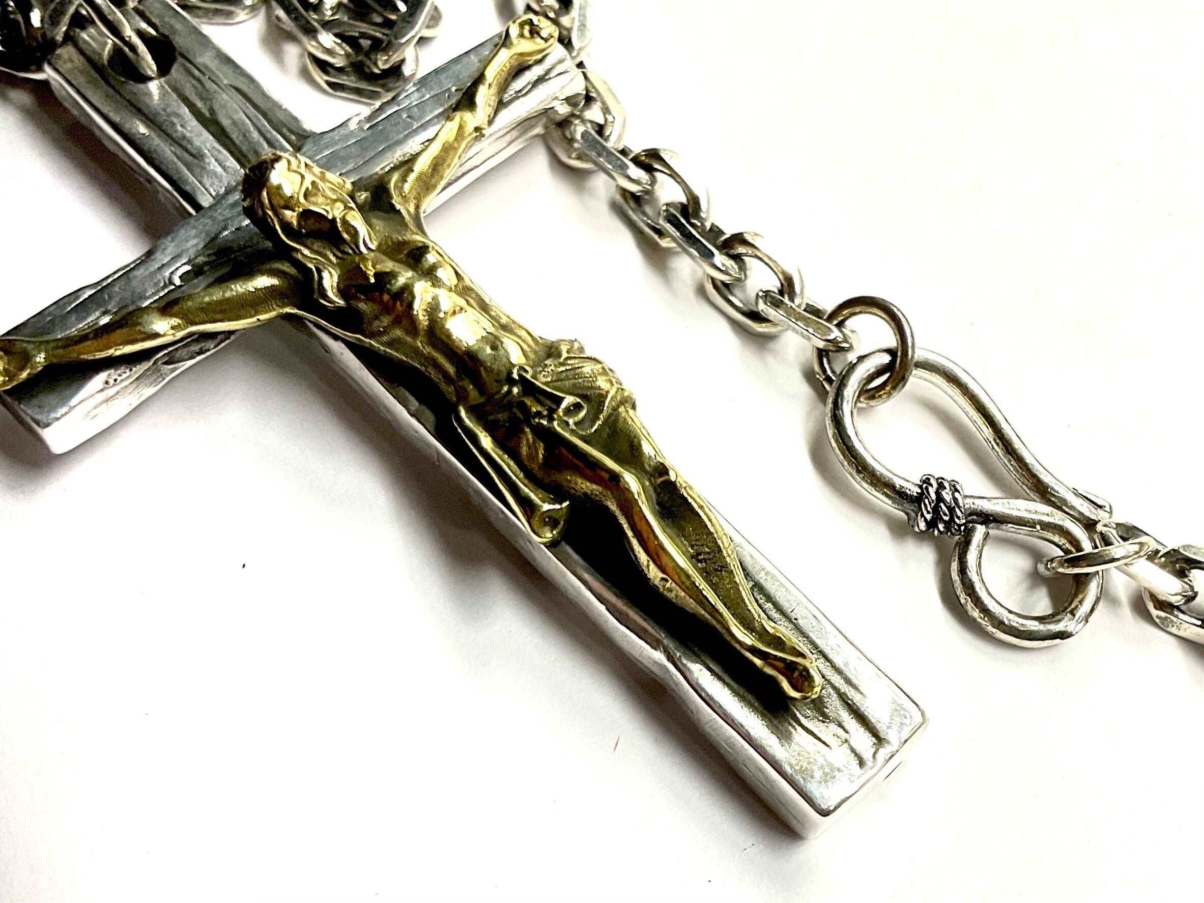 Crucifix cross necklace with silver and gold-toned figure and attached chain