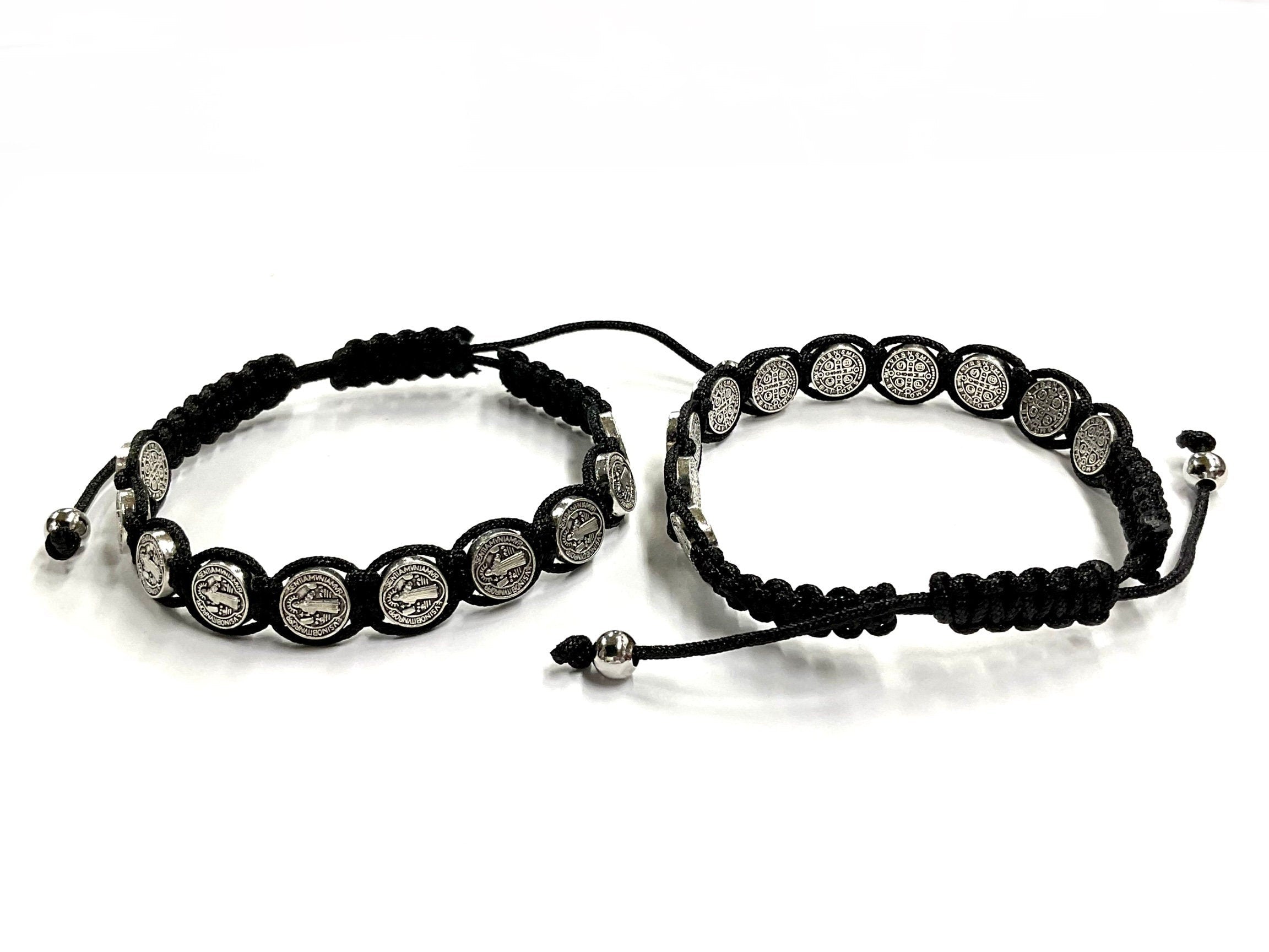 Two black woven string bracelets with round silver-tone coin medallions and pull ties