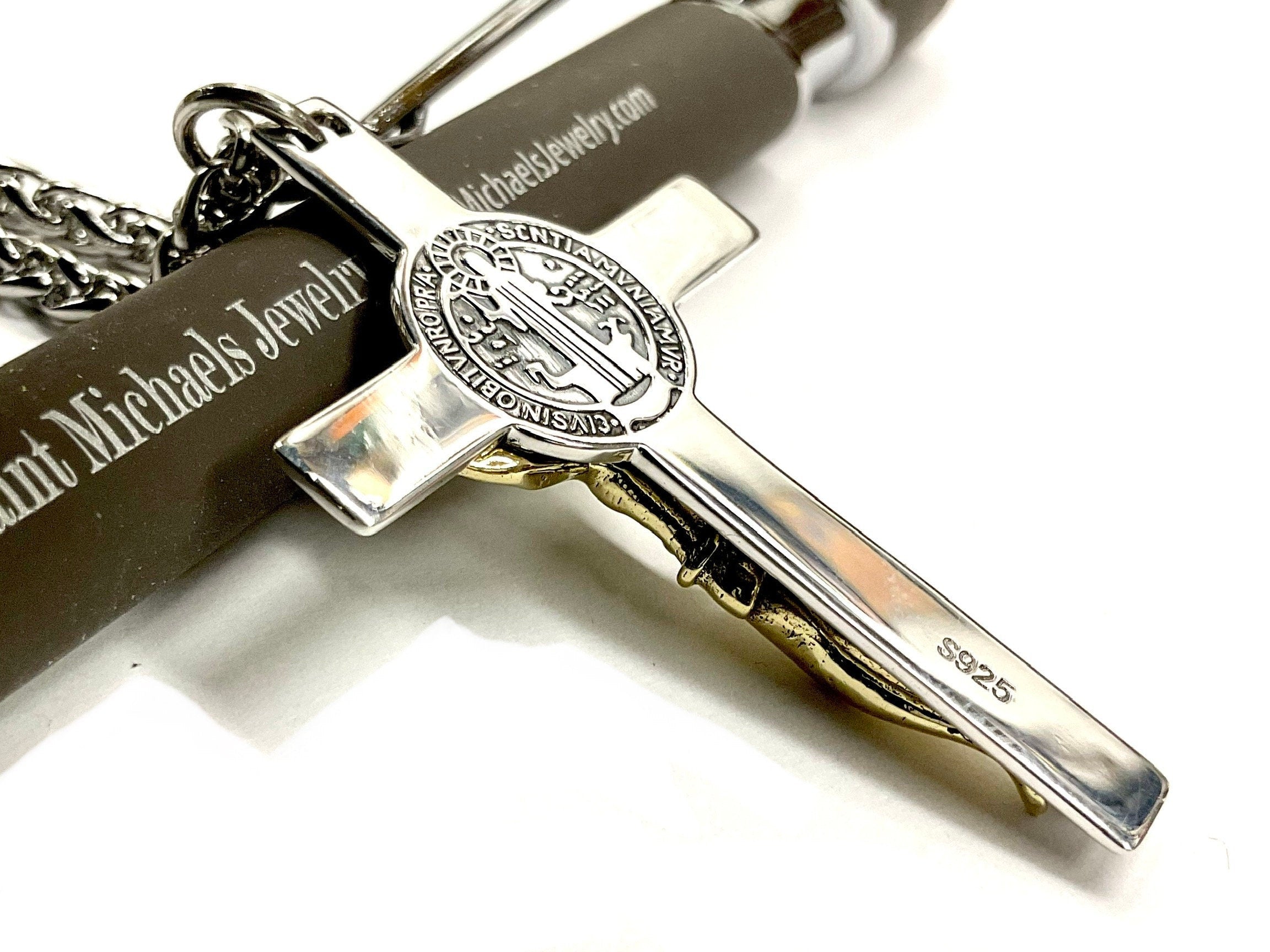 Silver and gold-tone crucifix pendant marked S925 on the cross arm