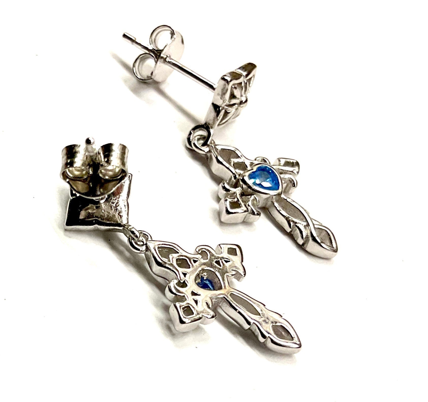 Sterling silver cross dangle earrings with blue zircon stones, side view