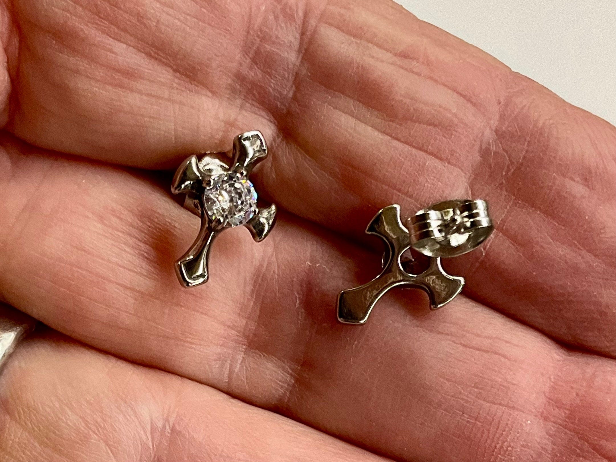 Silver cross stud earrings with round zircon; close-up shows front and back posts