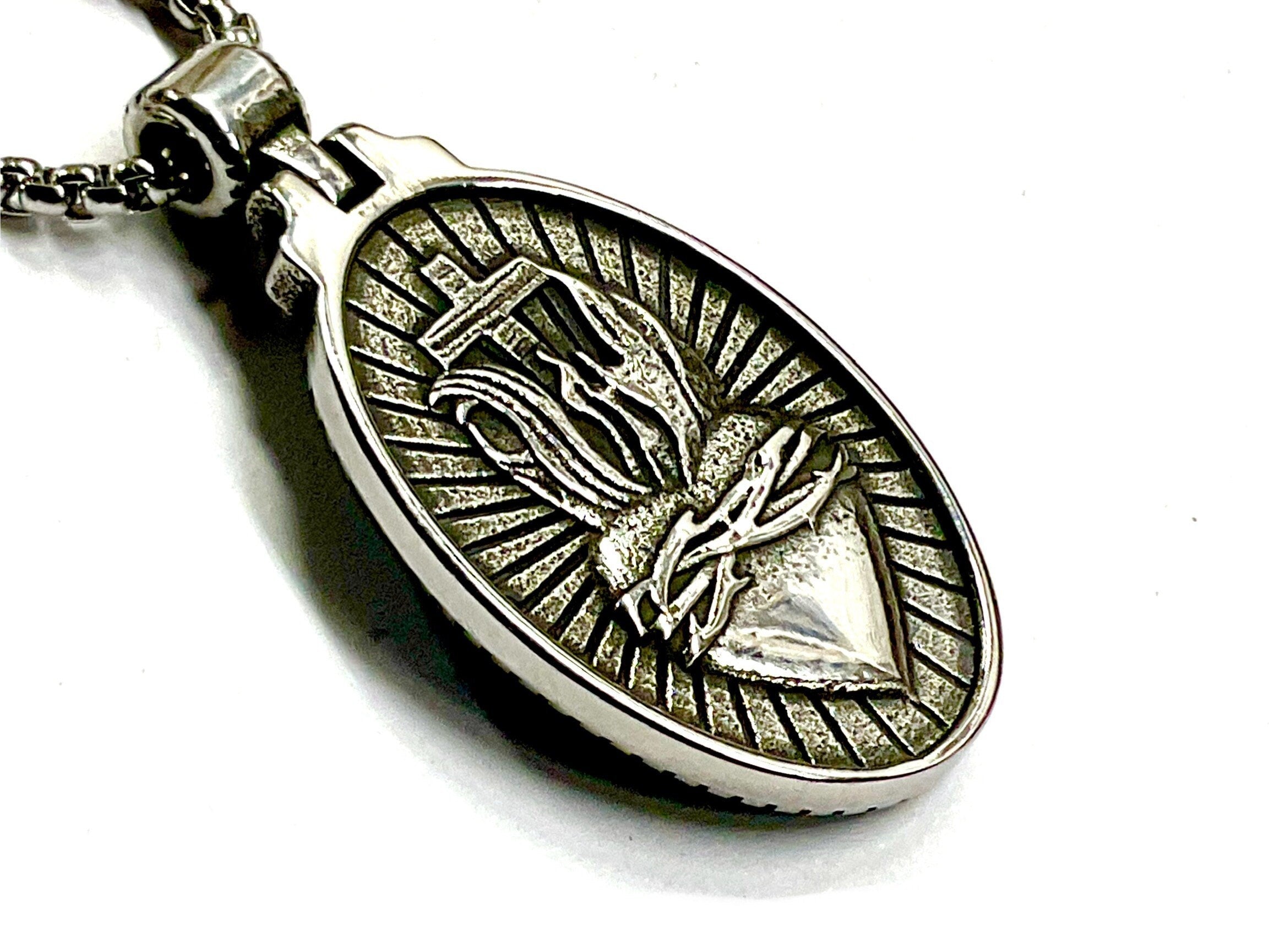 Oval metal religious pendant on link chain, relief Sacred Heart style