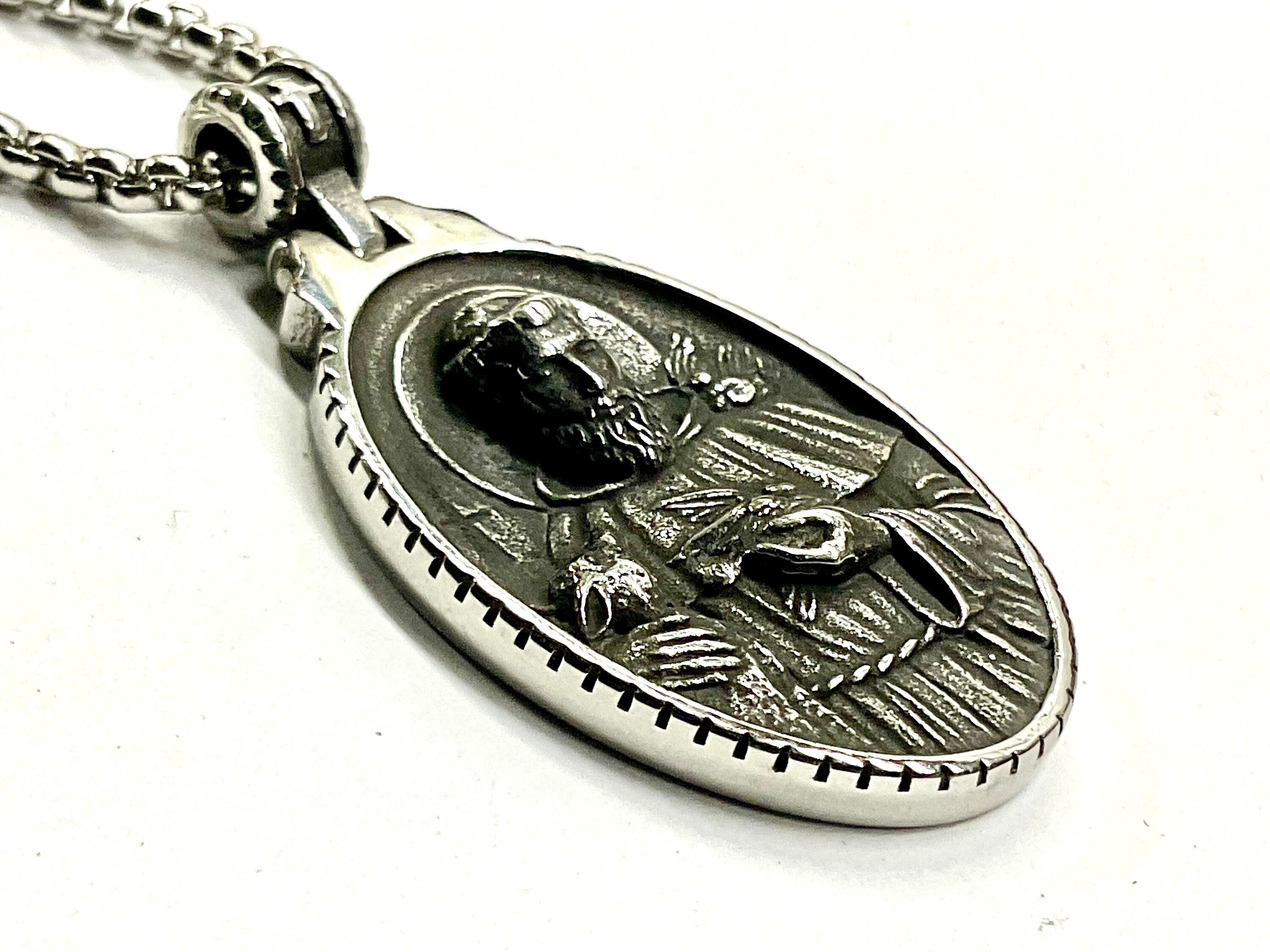 Oval metal medal pendant on link chain with relief figure