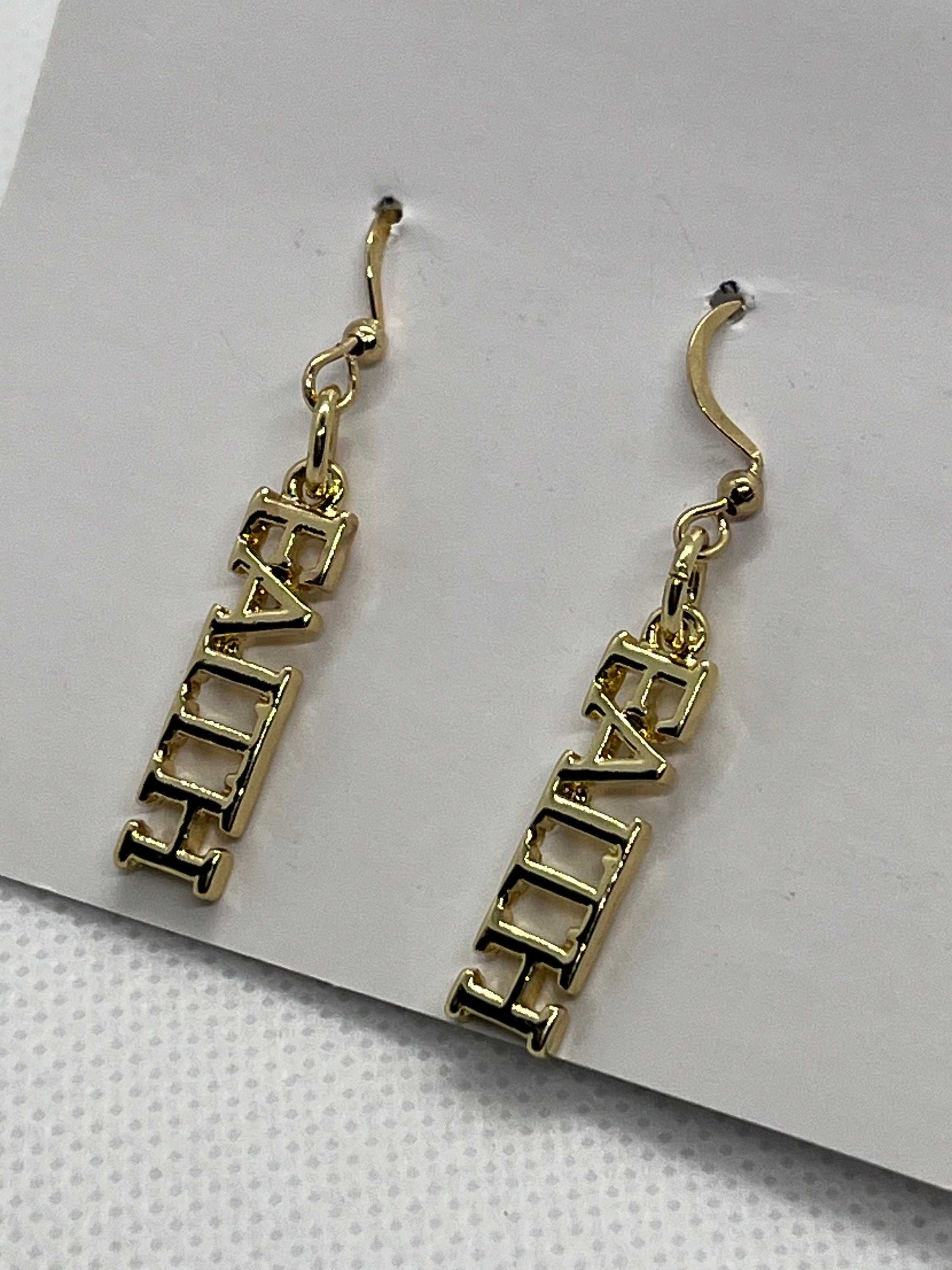 14K gold faith dangle earrings showing FAITH block lettering in profile
