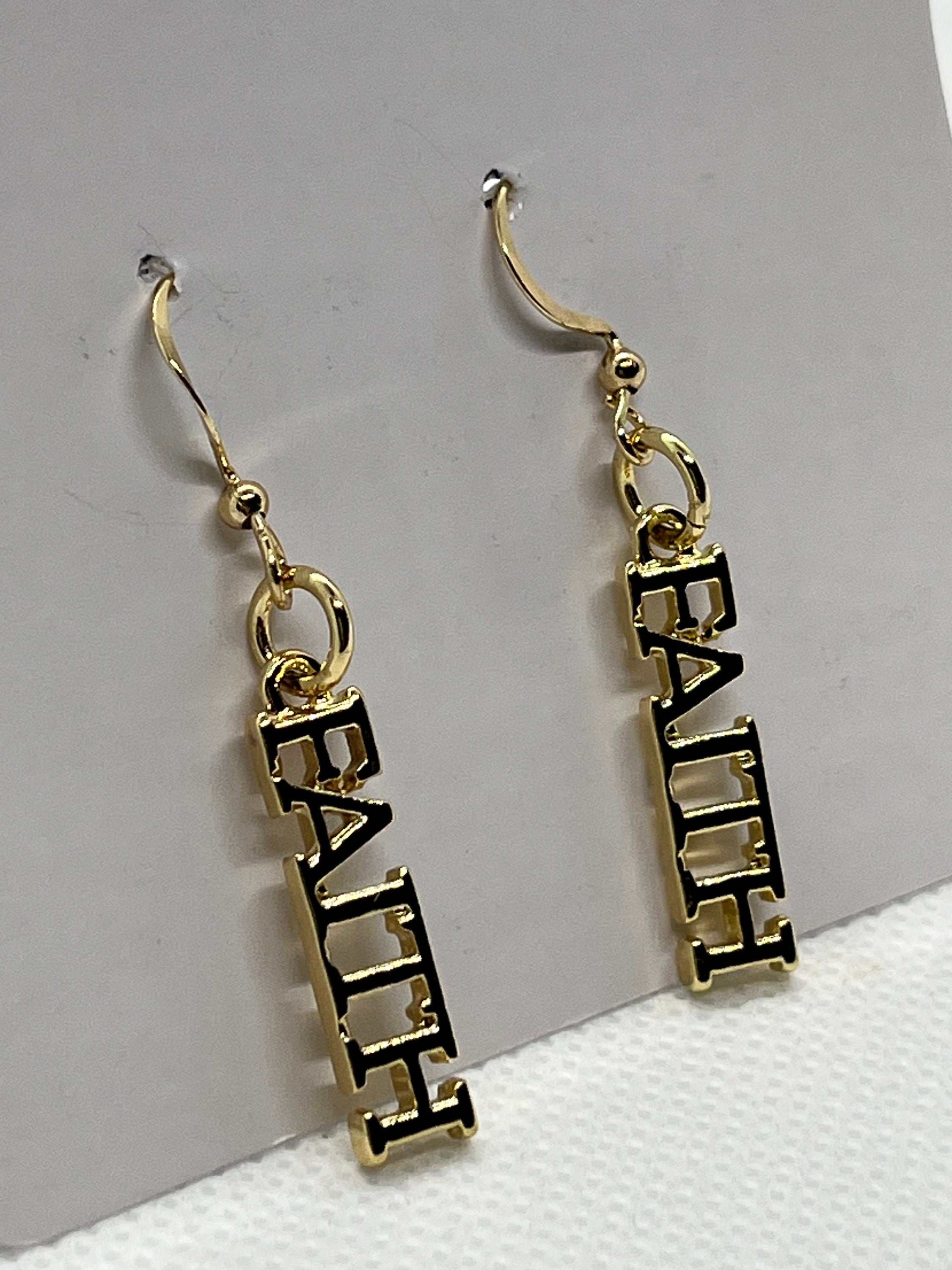 Close-up: 14K gold faith dangle earrings with FAITH block lettering and hooks