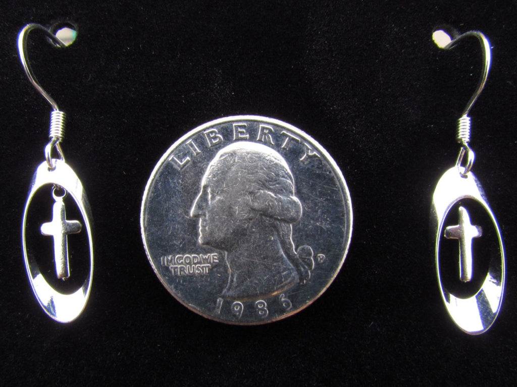 Silver cross earrings with oval drops, shown beside a coin for scale