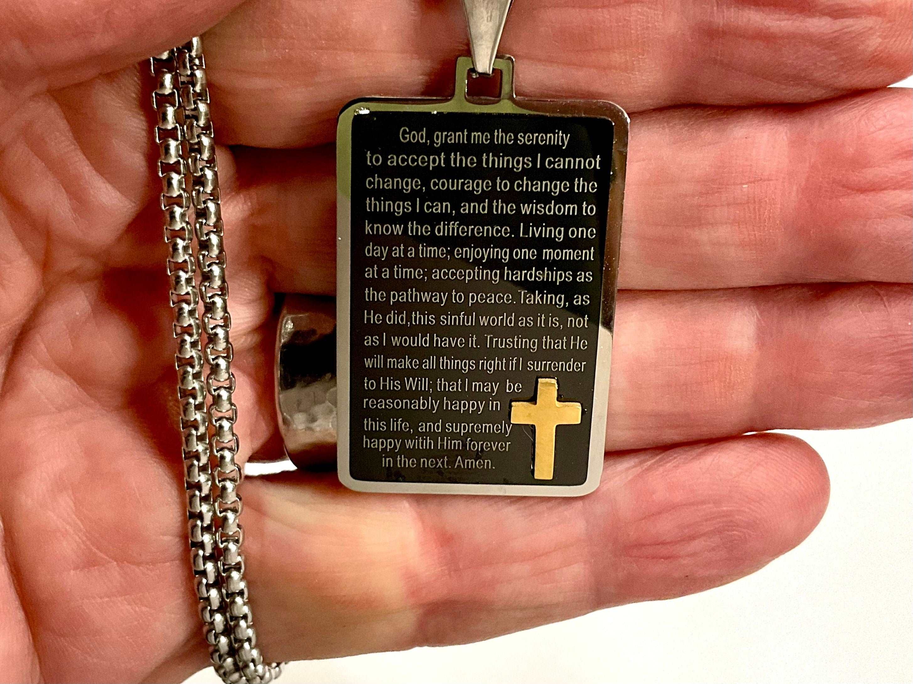 Black serenity prayer dog tag pendant with gold cross inset and chain, close-up