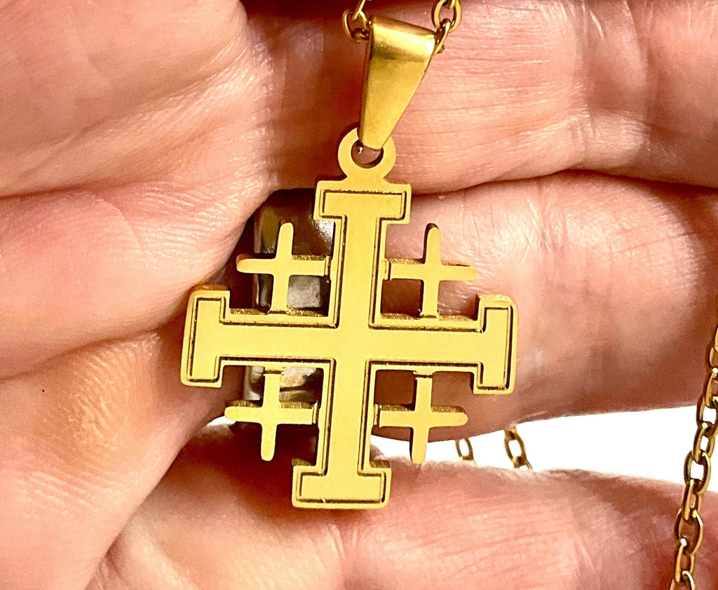 Gold Jerusalem cross pendant on chain, close-up in hand showing geometric details