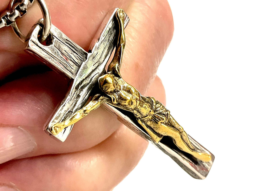 Silver cross necklace with gold-toned crucifix figure and polished bail