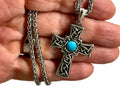 Silver cross necklace with Celtic-style knot and blue round stone; chain detail