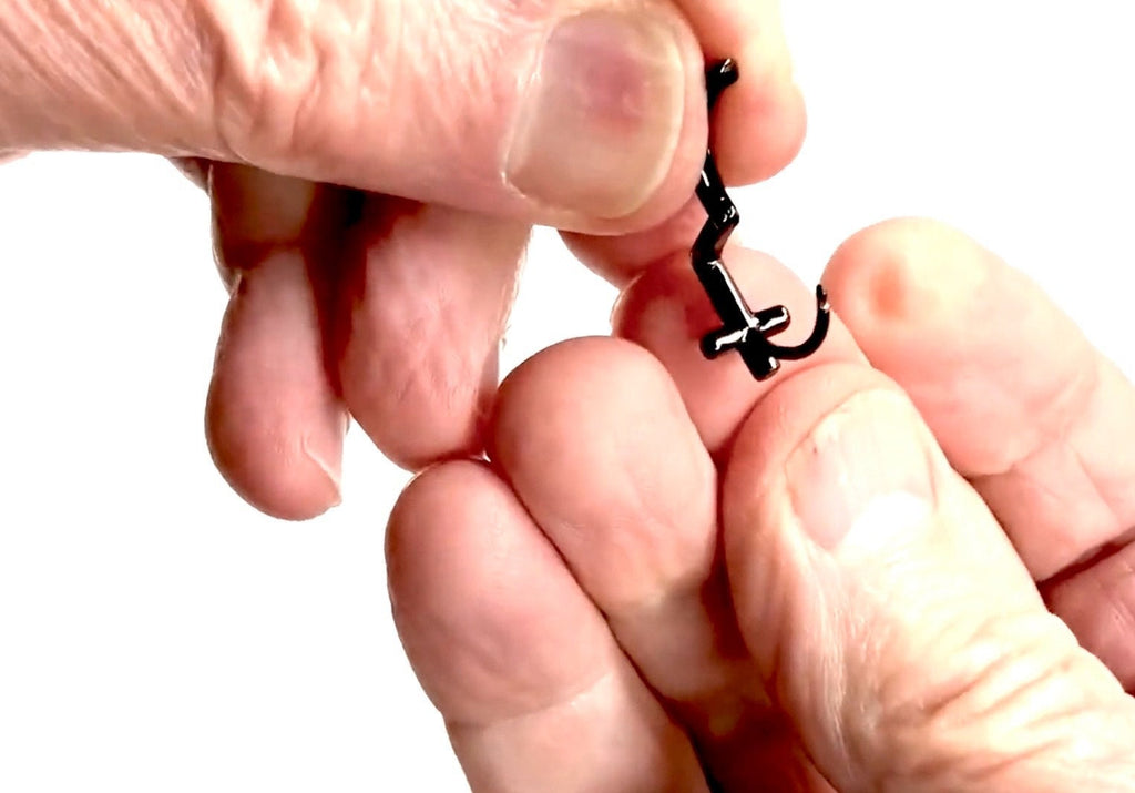Cross hoop cuff earring on fingers, hinged back clasp visible