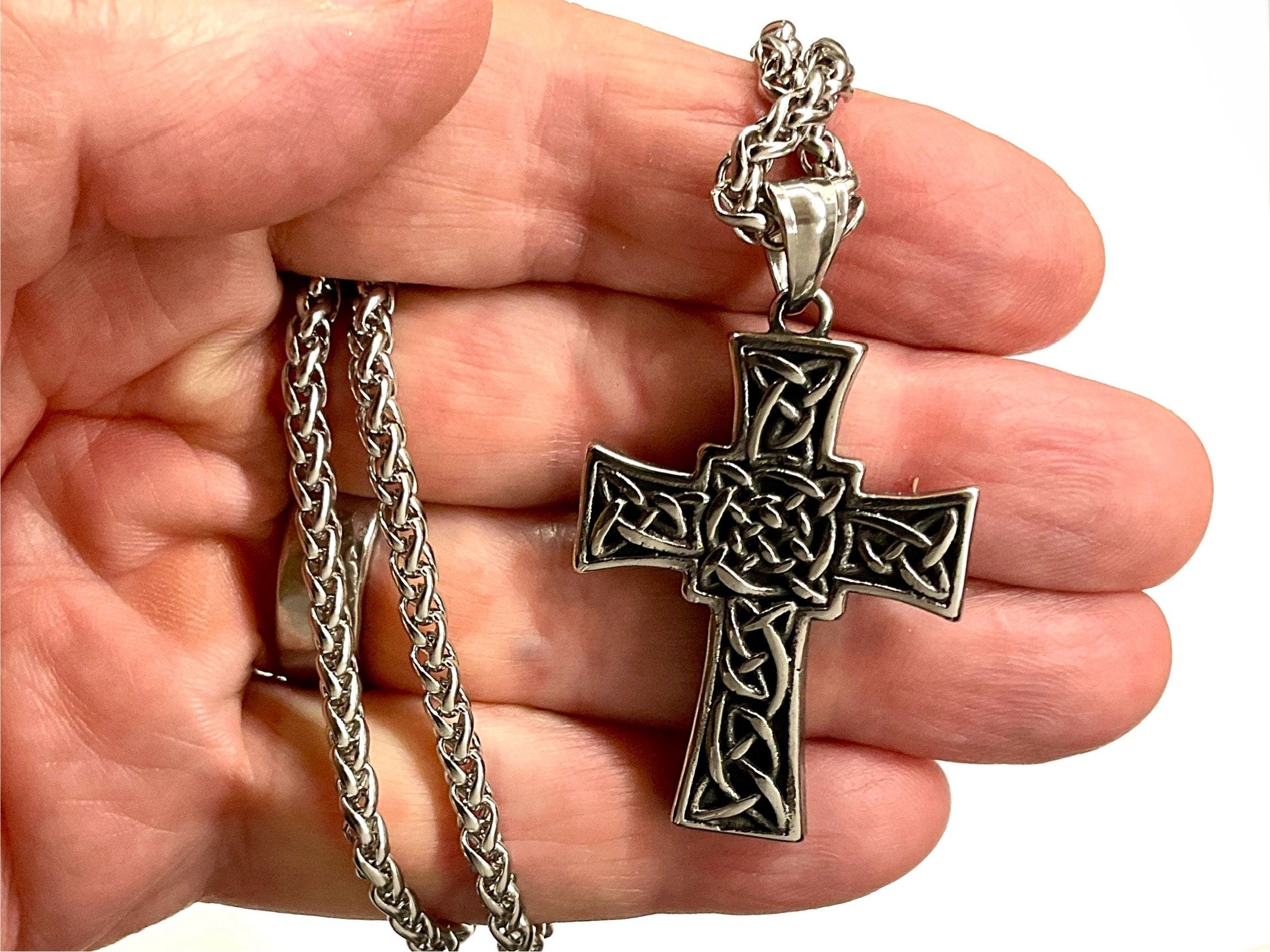 Silver Celtic cross necklace with engraved knotwork; no stone, braided chain