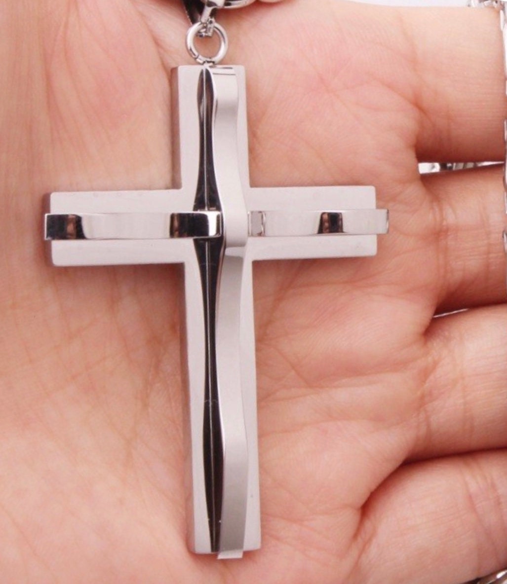 Silver cross pendant on chain, polished metal with side ridges