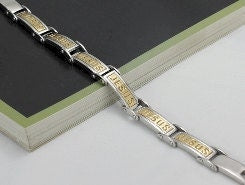 Silver bracelet with gold inset panels engraved JESUS, shown at an angle