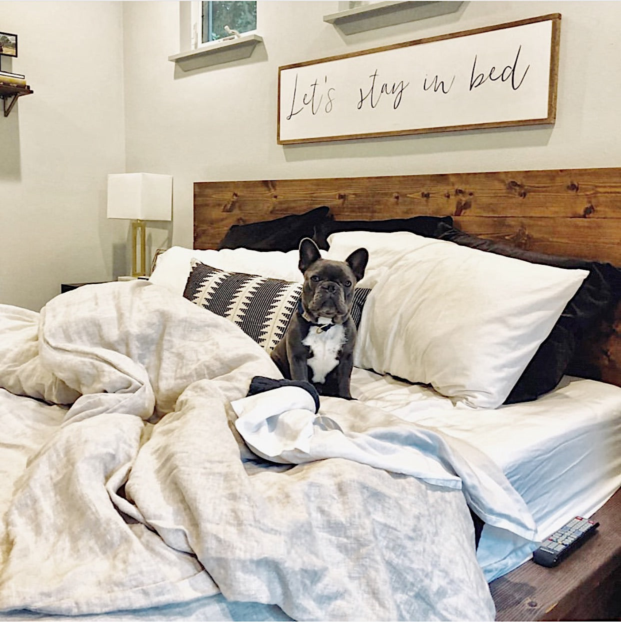 Let’s stay in bed wall hanging with handwritten text on a wooden frame