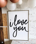 Modern wood wall sign with black cursive 'I love you' text