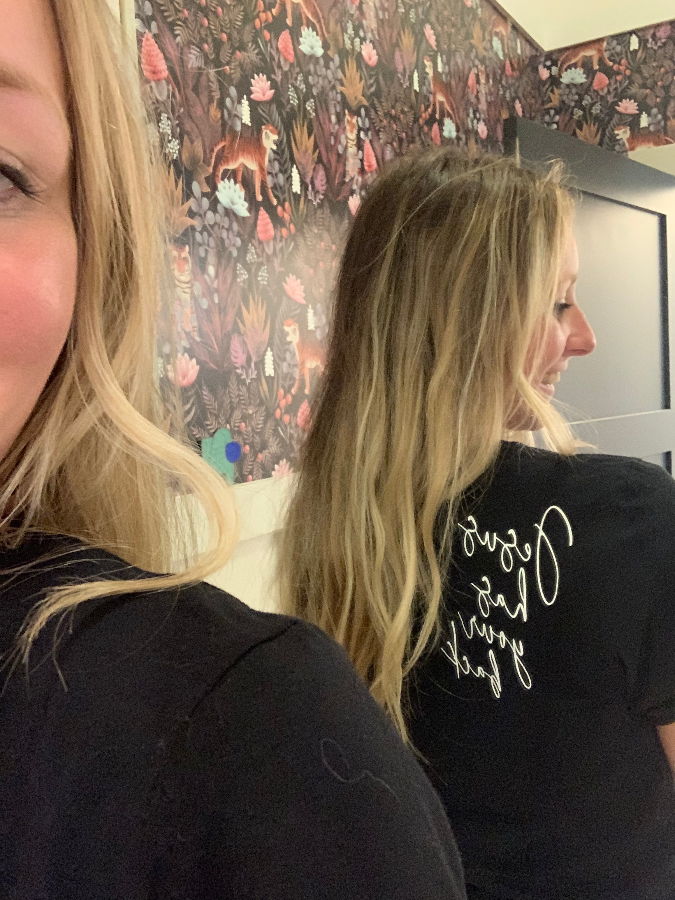 Black T-shirt with white script and floral outline on the back