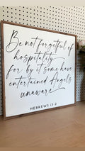 Framed wall sign with handwritten-style quote Hebrews 13:2 on white background