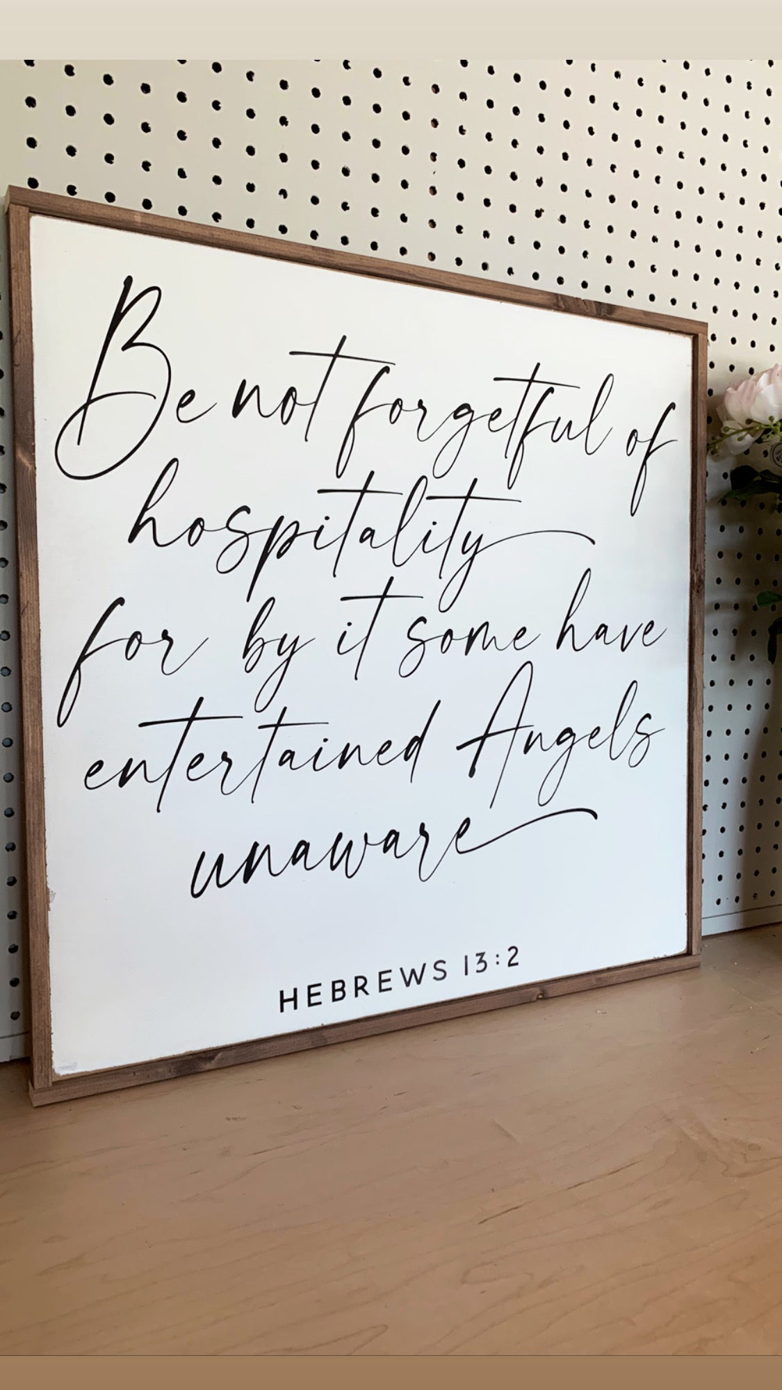 Framed wall sign with handwritten-style quote Hebrews 13:2 on white background