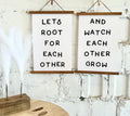 Framed wood wall signs with black lettering: LET’S ROOT… and WATCH…GROW