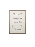 Framed quote wall sign with handwritten script inside a light wood frame.