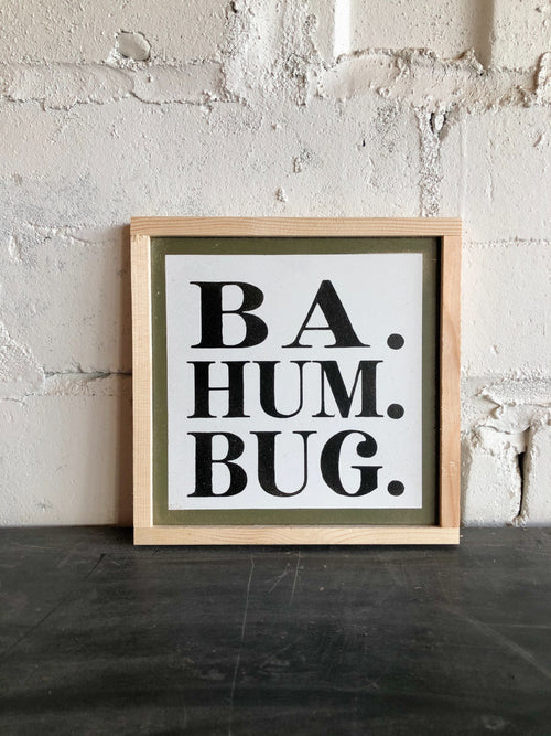 Framed wall art sign with 'BA. HUM. BUG.' black lettering and cream border