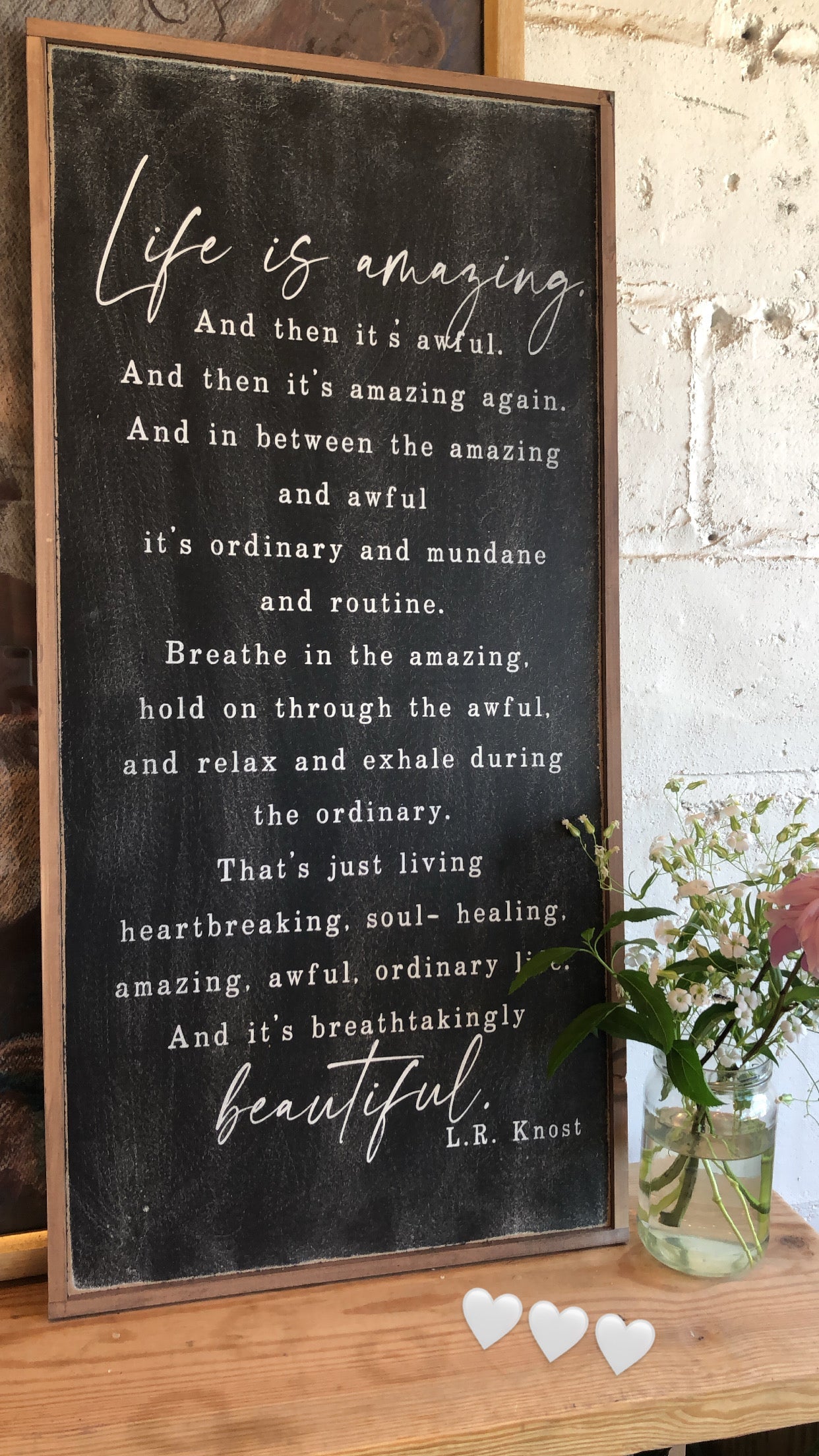 Framed wood interior sign with black background, white script quote and heart icons