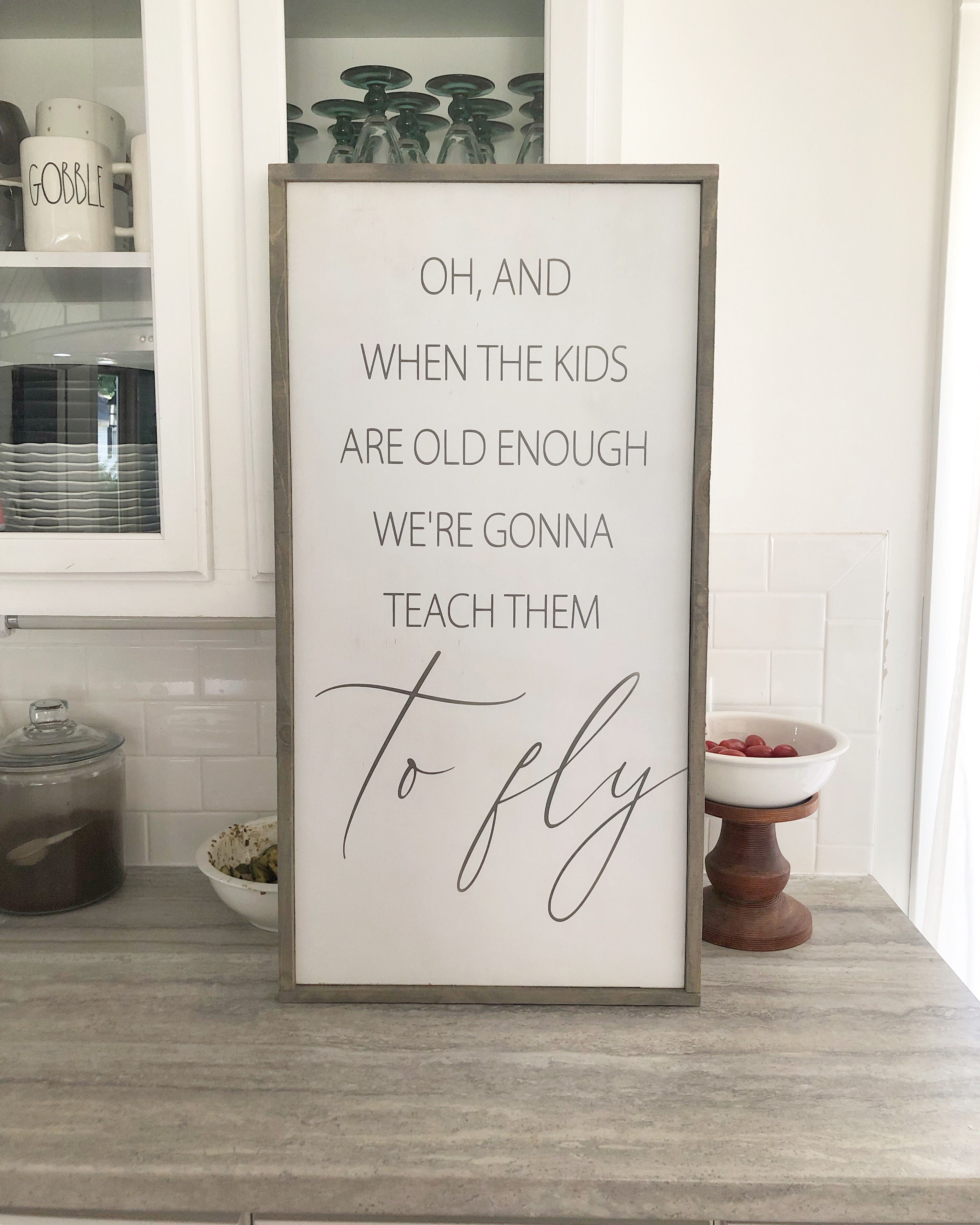 Framed wall quote sign with handwritten-style quote and 'to fly' script