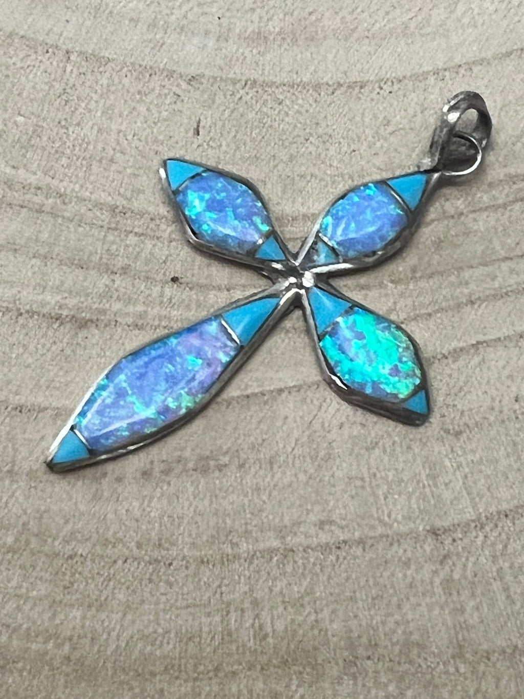 Turquoise opalite cross pendant viewed from the front, star-like inlay stones and bail