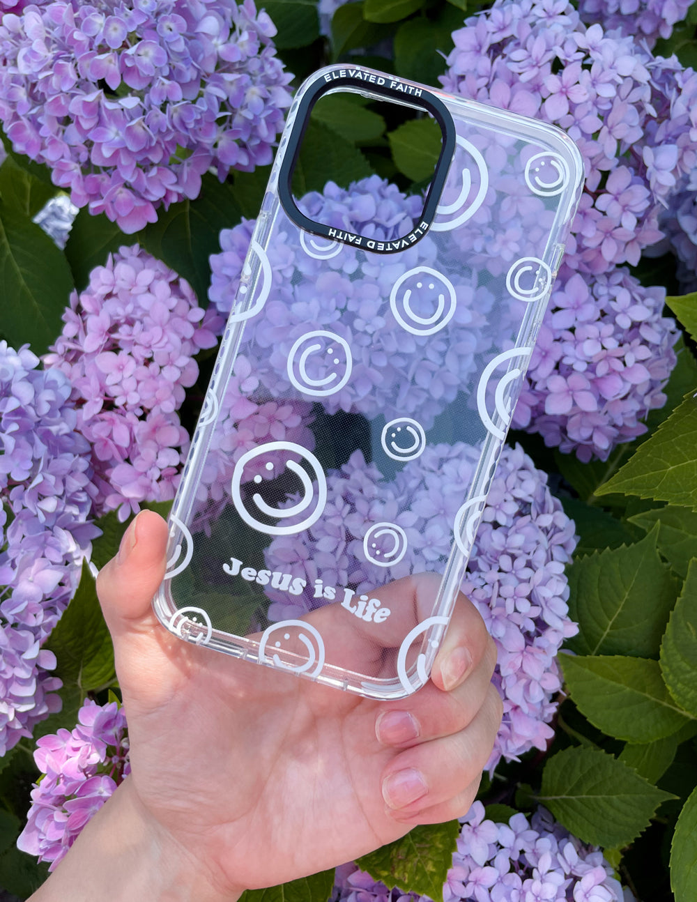 Clear purple phone case with circular smiley icons and Jesus is Life text