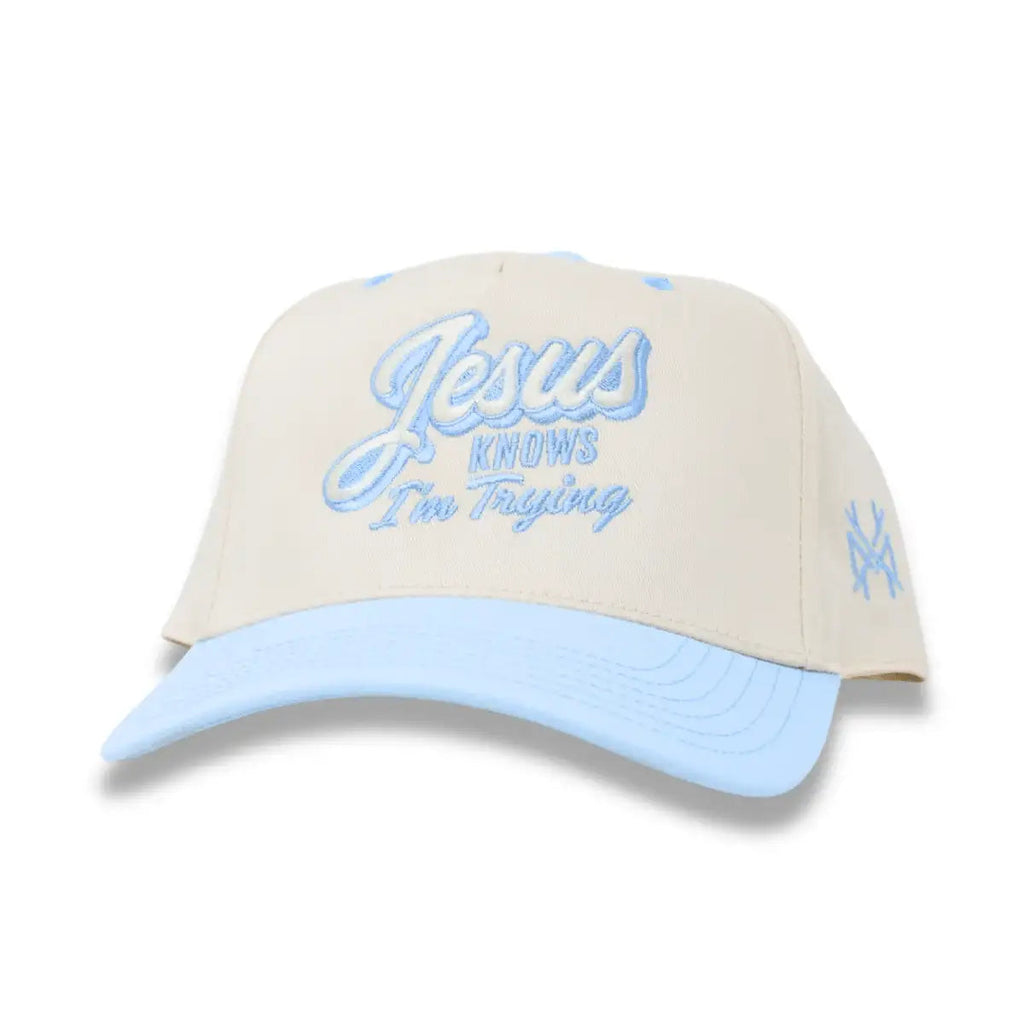 Cream and light blue snapback hat with front script logo and side embroidered crossmark