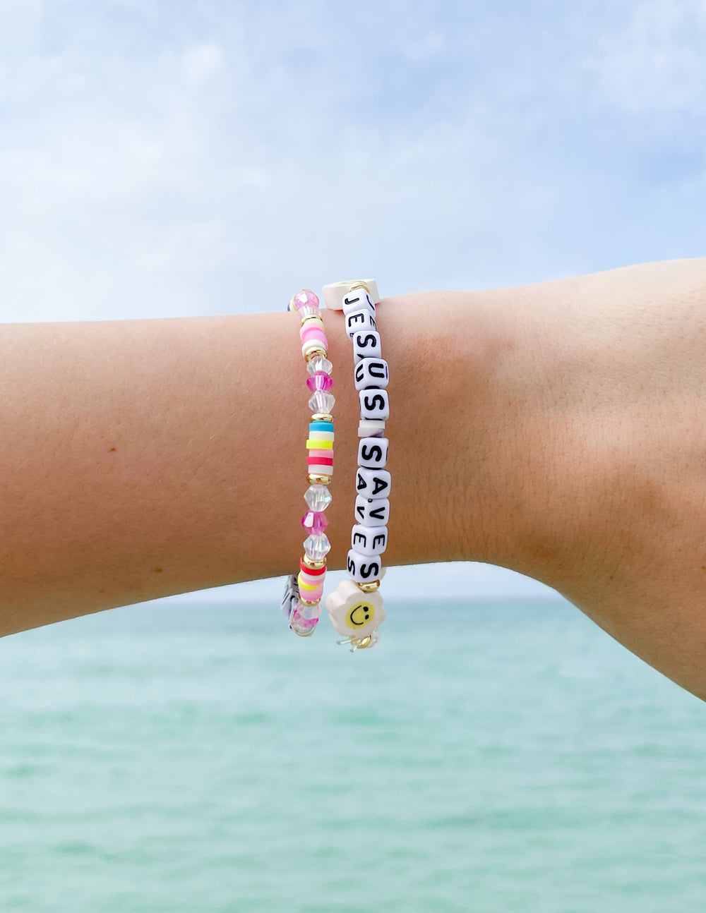 Beaded letter bracelet on wrist with 'Jesus Saves' tiles and colorful round beads